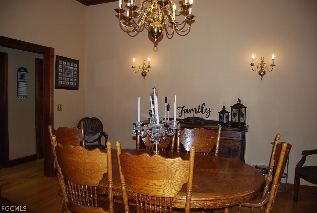 3480 4th Avenue Southeast Naples, FL 34117 - Photo 12 of 15 a dining room with furniture a chandelier and wooden floor