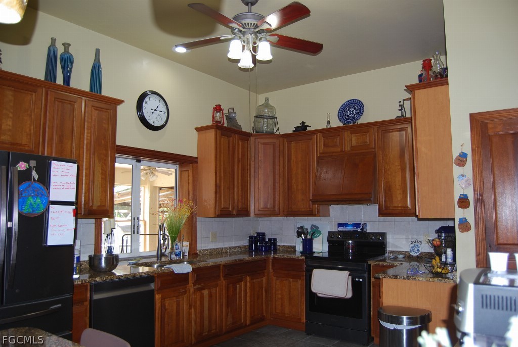 3480 4th Avenue Southeast Naples, FL 34117 - Photo 8 of 15 a kitchen with a refrigerator a stove top oven a sink and furniture