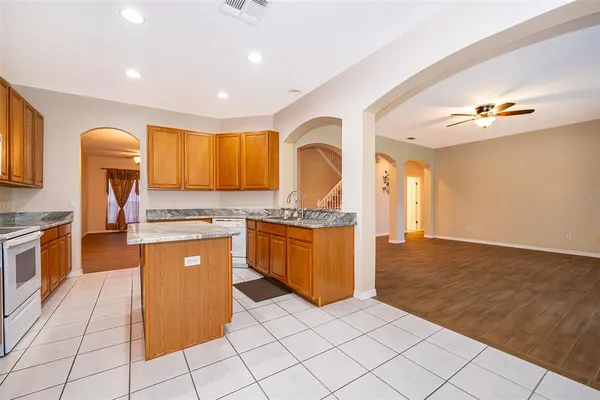 a large kitchen with stainless steel appliances granite countertop a sink and cabinets