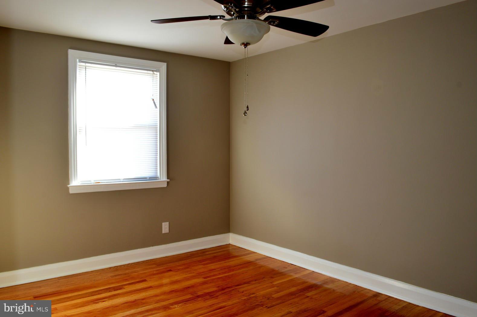 5019 West Hills Road Baltimore, MD 21229 - Photo 25 of 30 a view of an empty room with wooden floor and a window