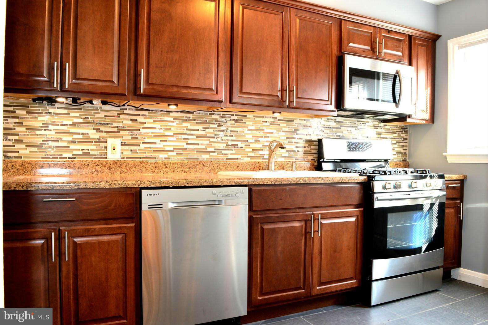 5019 West Hills Road Baltimore, MD 21229 - Photo 7 of 30 a kitchen with granite countertop cabinets stainless steel appliances and a sink