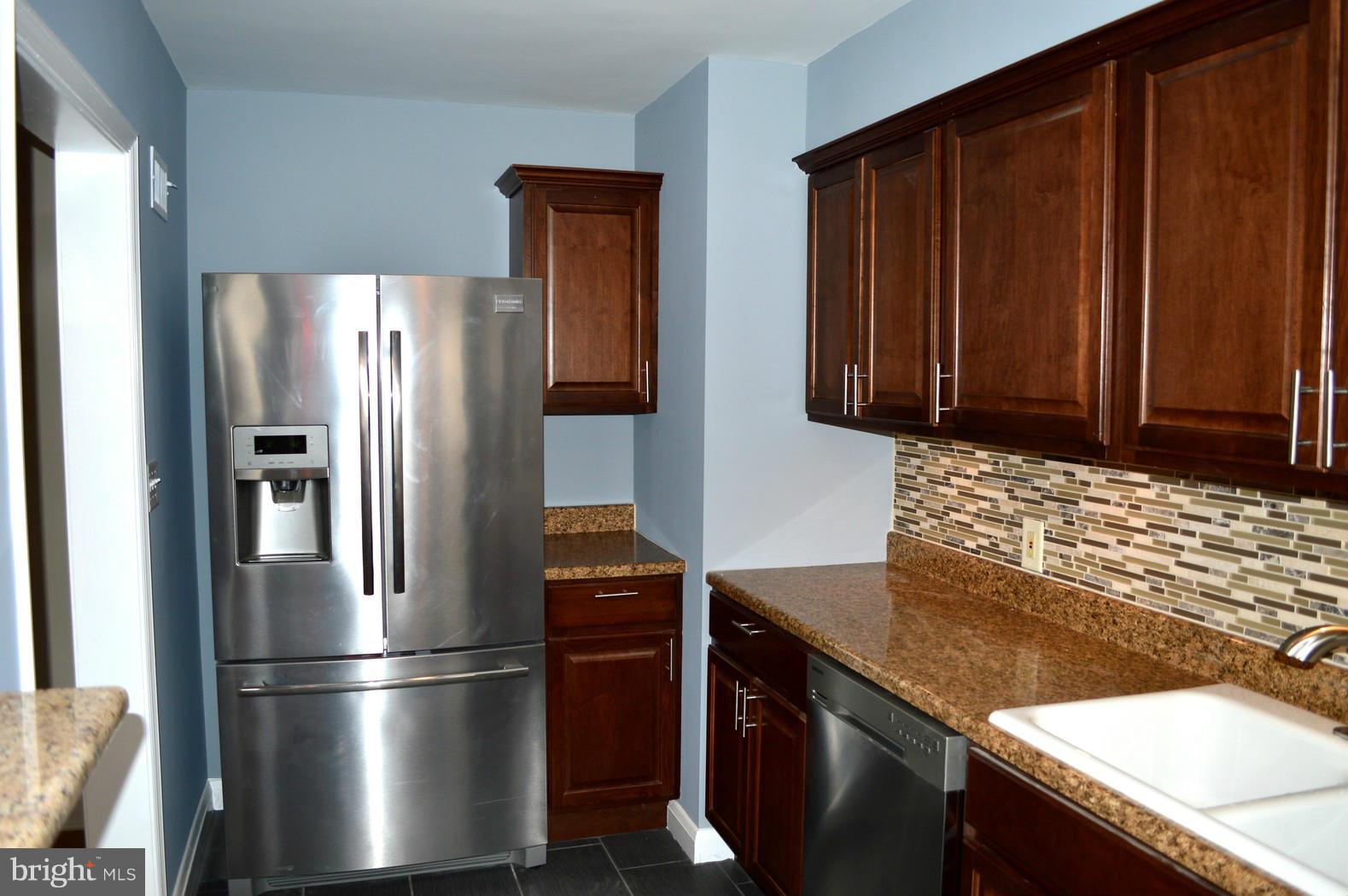 5019 West Hills Road Baltimore, MD 21229 - Photo 8 of 30 a kitchen with granite countertop stainless steel appliances and wooden cabinets