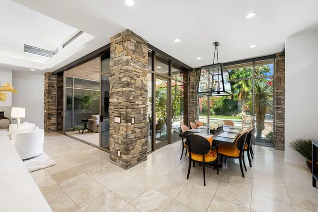 a dining room with furniture and a large window