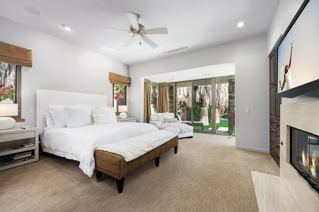 a spacious bedroom with a bed couch and a large window