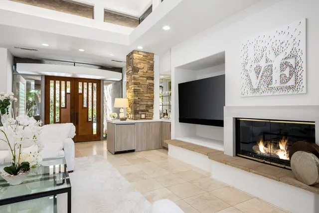 a living room with furniture a fireplace and a flat screen tv
