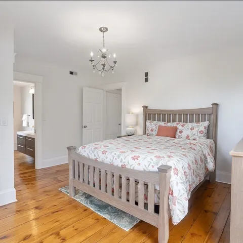 a bedroom with a bed and wooden floor