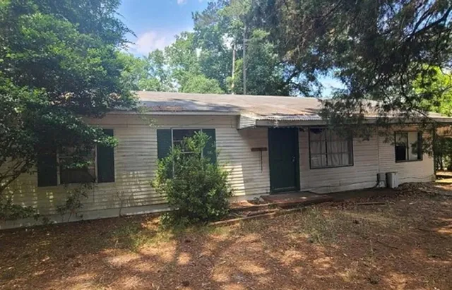 a view of a house with a large window and a large tree