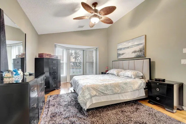 a bedroom with a large bed and a chandelier