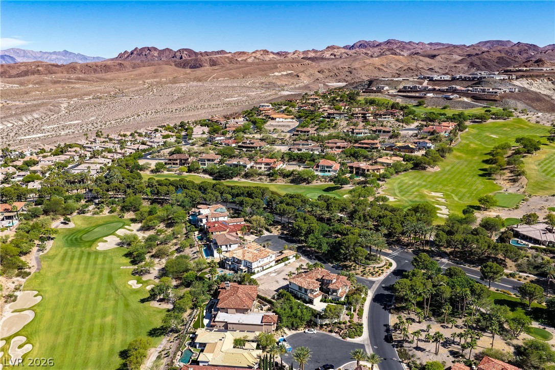 6 Rue Du Ville Henderson, NV 89011 - Photo 96 of 99 An aerial perspective reveals an expansive community nestled beside a verdant golf course with mountainous backdrops.
