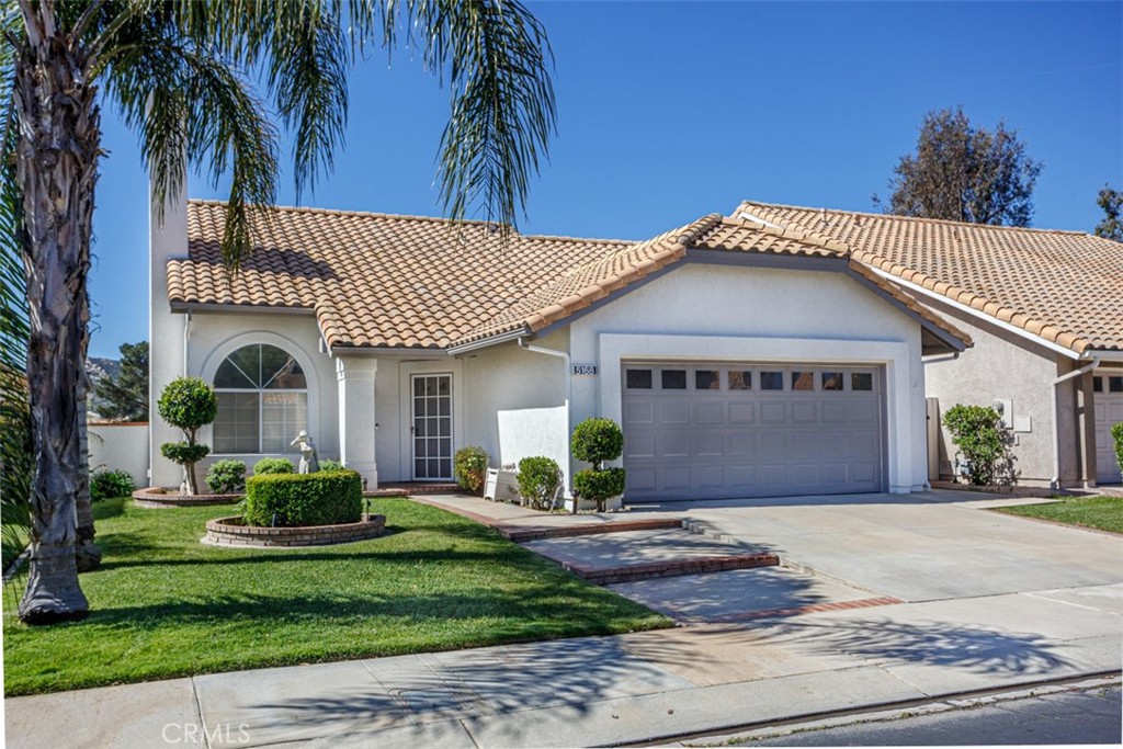 a front view of a house with a garden and plants