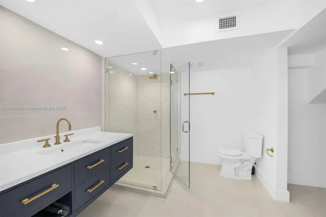 a bathroom with a toilet a sink a mirror and a shower