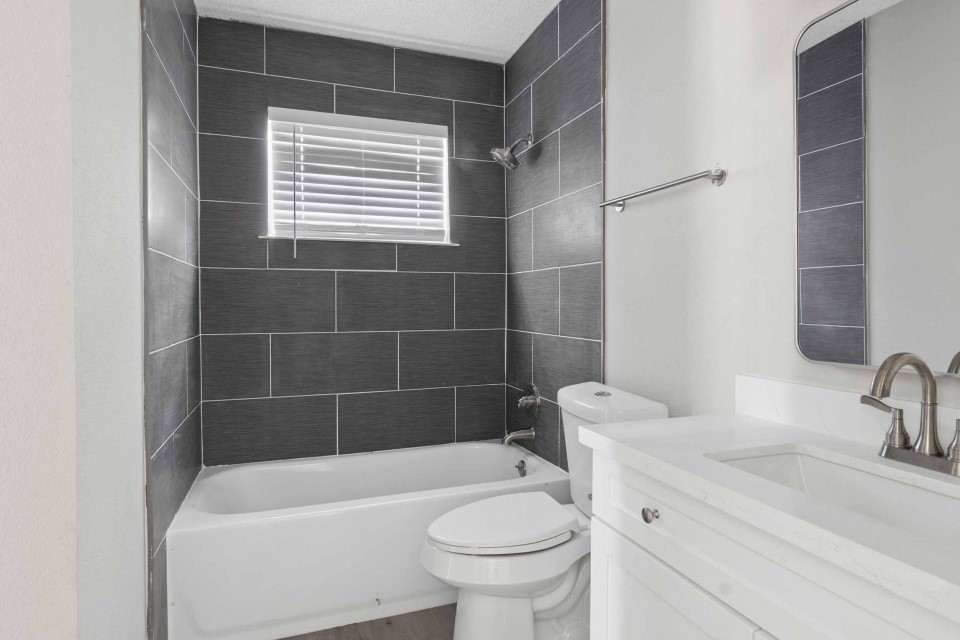 7403 Strawbridge Lane Houston, TX 77040 - Photo 18 of 22 a bathroom with a sink a toilet a mirror and shower