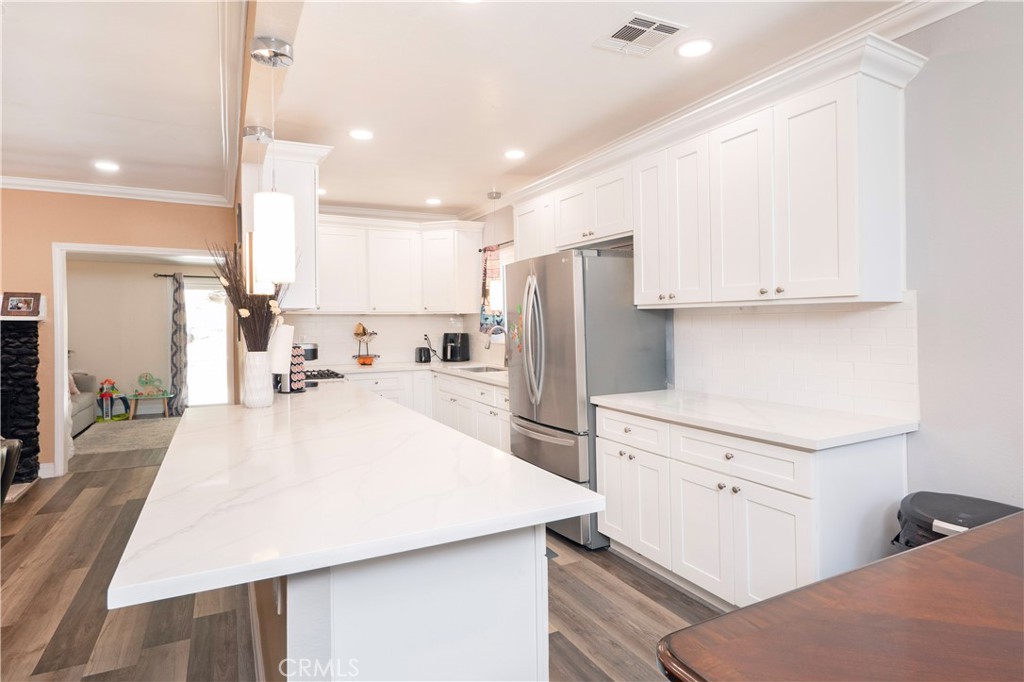 18839 Deer Trail Road Banning, CA 92220 - Photo 19 of 47 a large kitchen with kitchen island a sink a stove a refrigerator and white cabinets