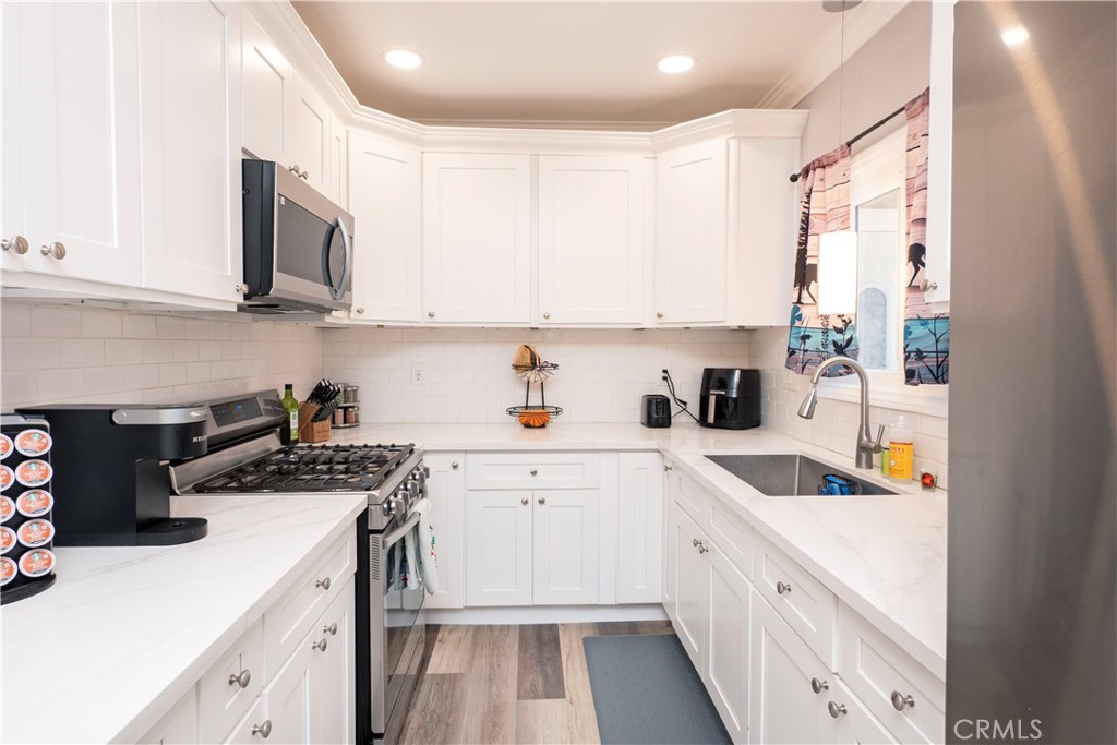 18839 Deer Trail Road Banning, CA 92220 - Photo 20 of 47 a kitchen with stainless steel appliances granite countertop a sink stove and white cabinets