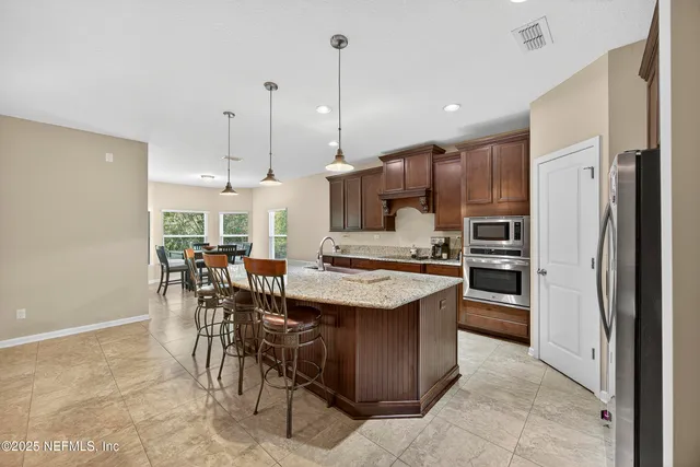 a kitchen with stainless steel appliances granite countertop a sink stove and refrigerator