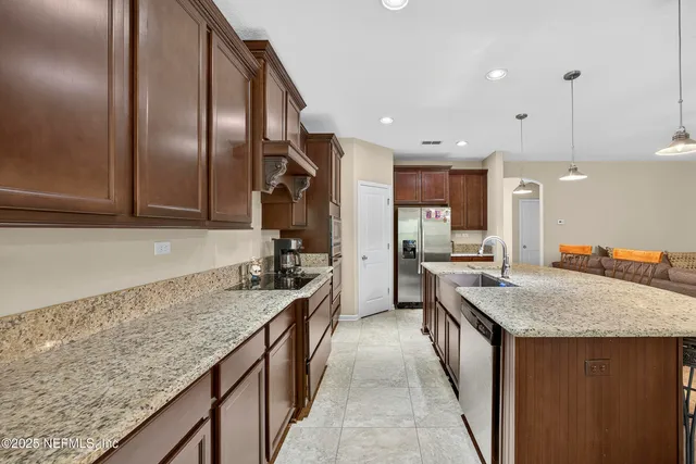 a kitchen with stainless steel appliances granite countertop a kitchen island a table and chairs in it