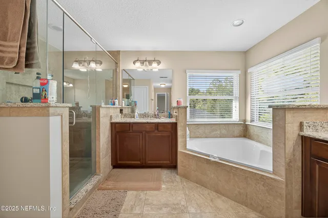 a bathroom with a double vanity sink mirror and shower