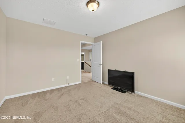 a living room with a bed furniture and a ceiling fan