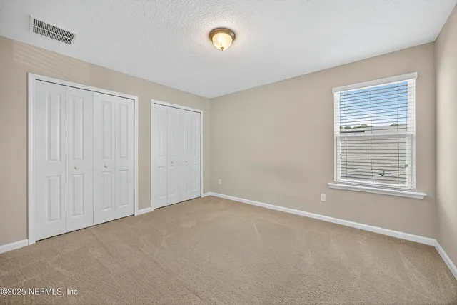 a view of a livingroom with furniture hardwood floor ceiling fan and a large window