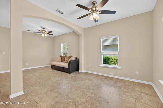 a living room with furniture and a ceiling fan