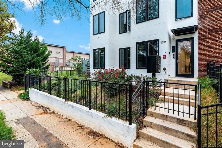 a view of house with large windows and a small yard