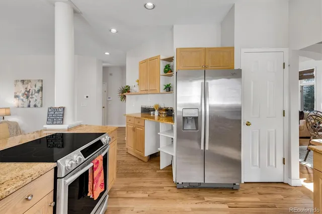 a kitchen with stainless steel appliances granite countertop a refrigerator and a stove top oven