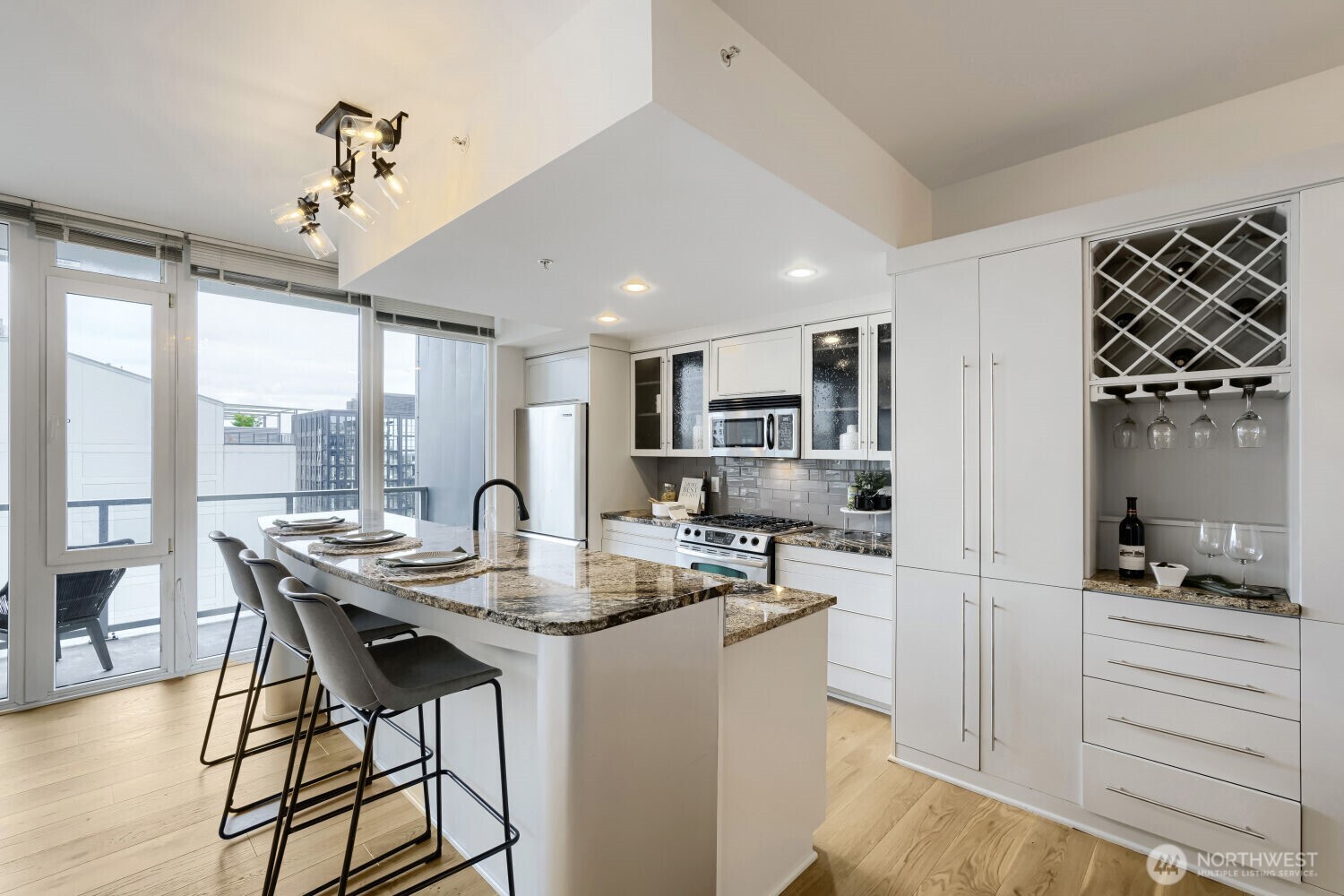 76 Cedar Street, Unit 1109 Seattle, WA 98121 - Photo 15 of 28 a kitchen with a table chairs refrigerator and microwave