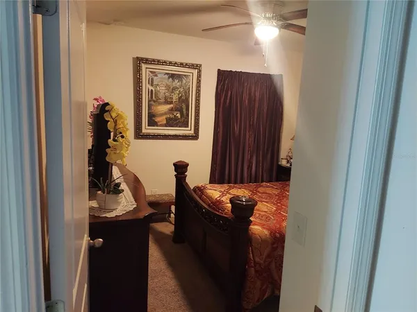 a view of a hallway with wooden floor and a bathroom