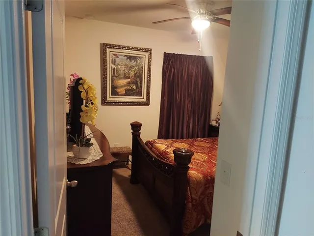 a view of a hallway with wooden floor and a bathroom