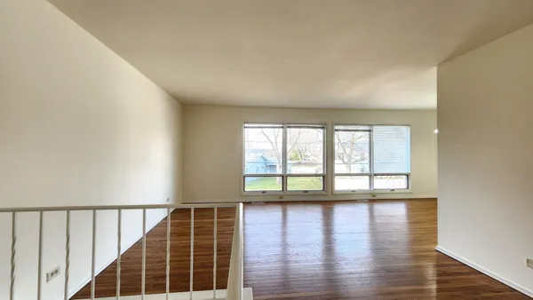 a view of wooden floor in an empty room with a window