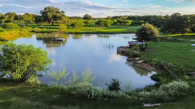 an aerial view of a house with a yard and lake view