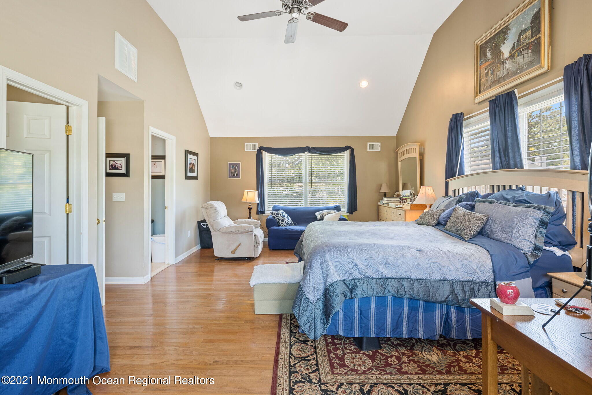 245 Crows Nest Road Manahawkin, NJ 08050 - Photo 31 of 79 a spacious bedroom with a bed a couch and a chandelier
