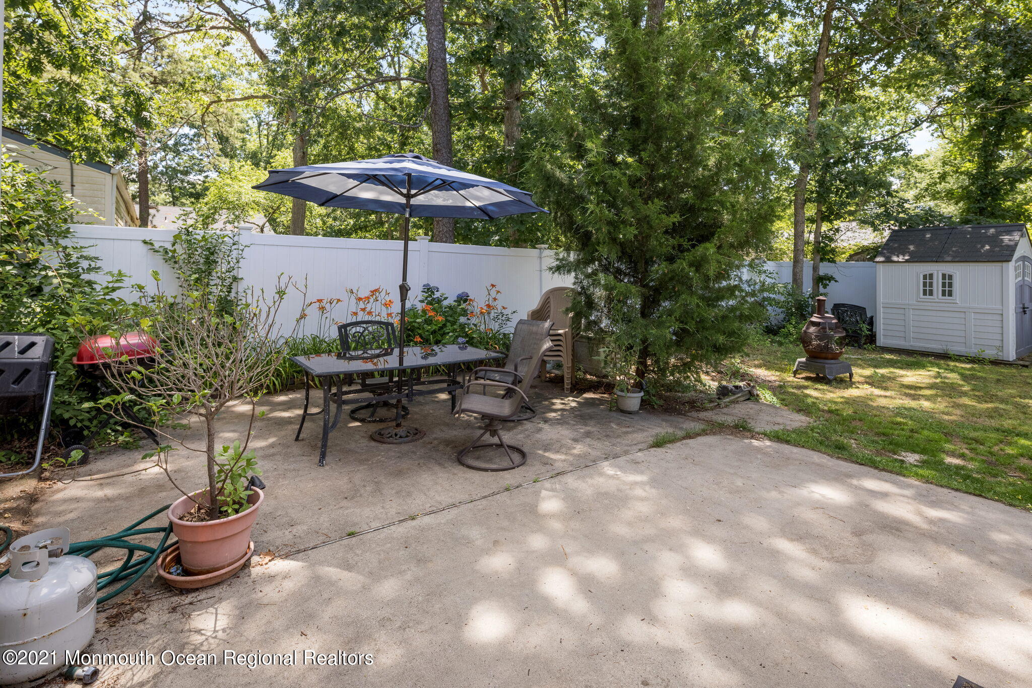 245 Crows Nest Road Manahawkin, NJ 08050 - Photo 43 of 79 a view of a backyard with potted plants and a umbrella