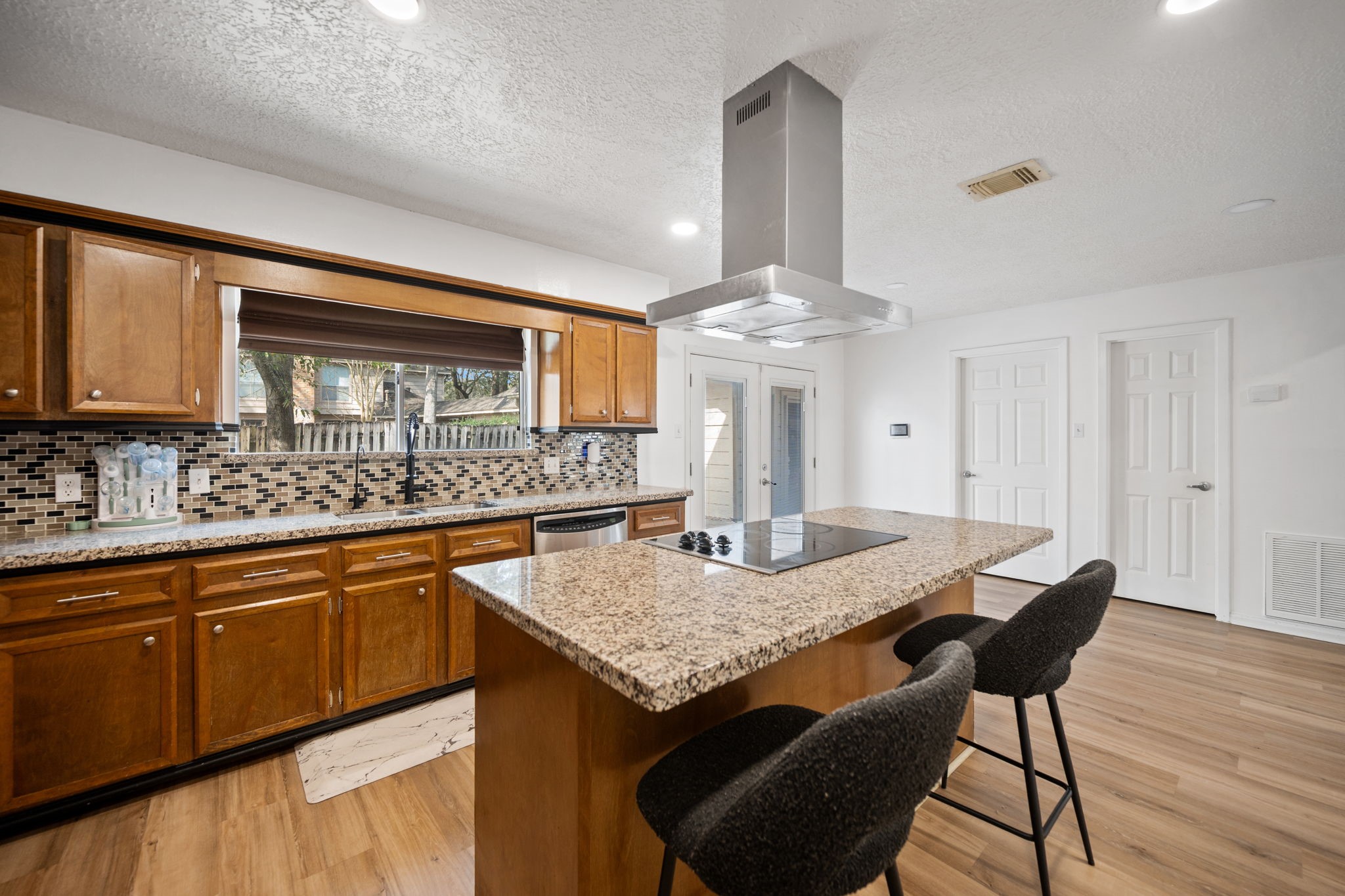 14907 Oak Bluff Court Houston, TX 77070 - Photo 6 of 19 a kitchen with stainless steel appliances granite countertop a kitchen island a stove a table and chairs in it
