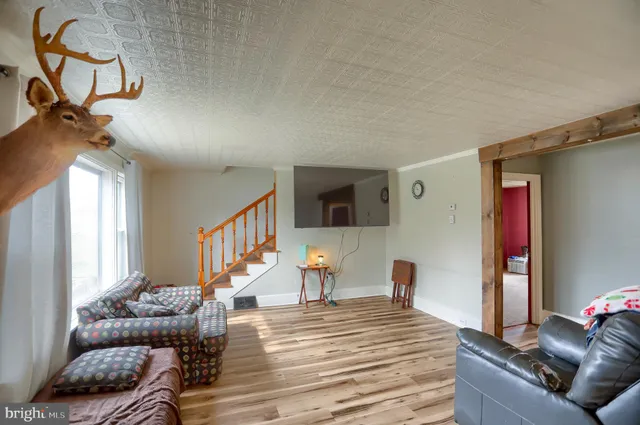 a living room with furniture stairs and a window