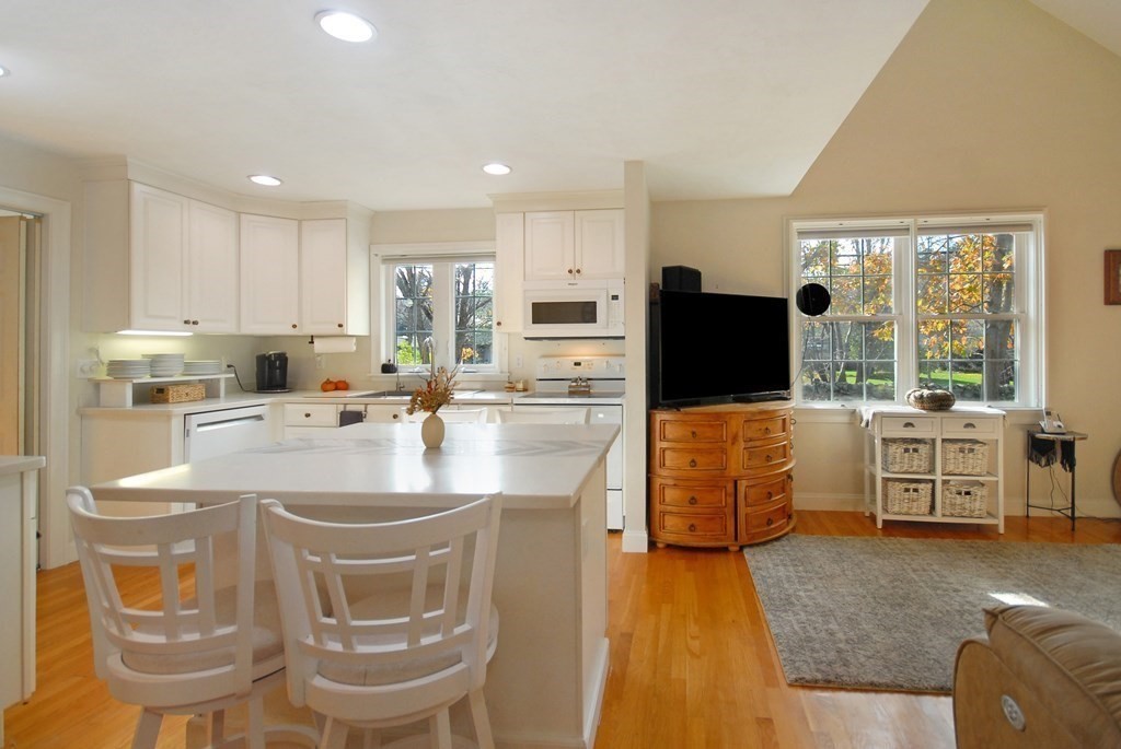 110 Summer Road, Unit 110 Boxborough, MA 01719 - Photo 10 of 28 a kitchen with stainless steel appliances granite countertop a stove a refrigerator a oven a white table and chairs