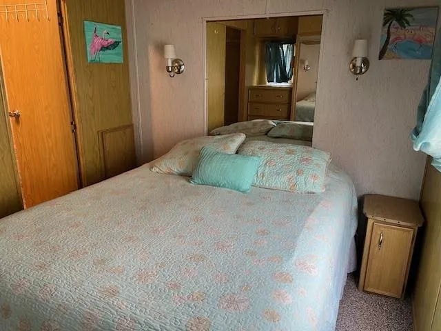 a bed sitting in a bedroom next to a small bathroom