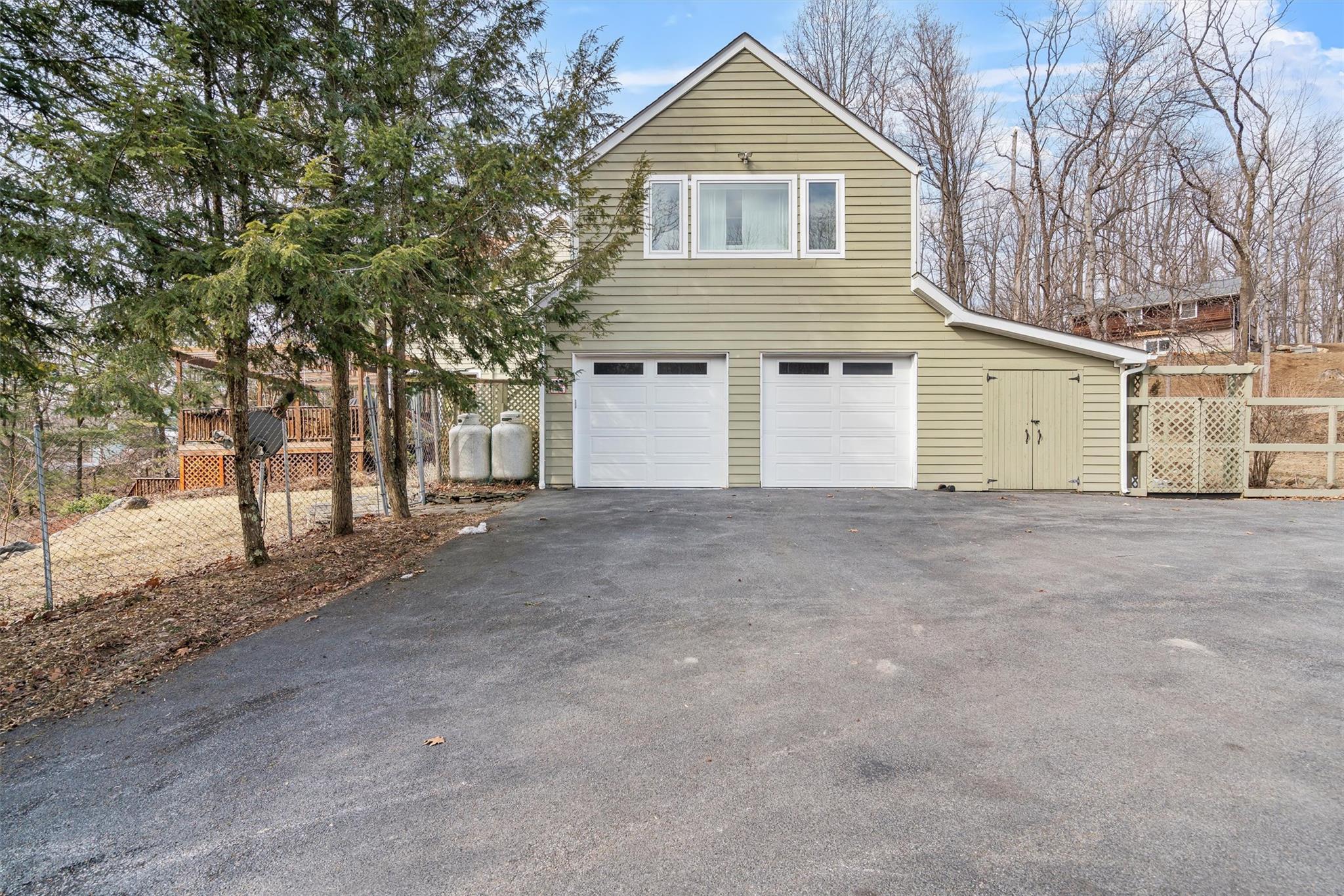 36 Chardavoyne Road Warwick, NY 10990 - Photo 41 of 46 View of side of home featuring aphalt driveway, an attached garage, and fence