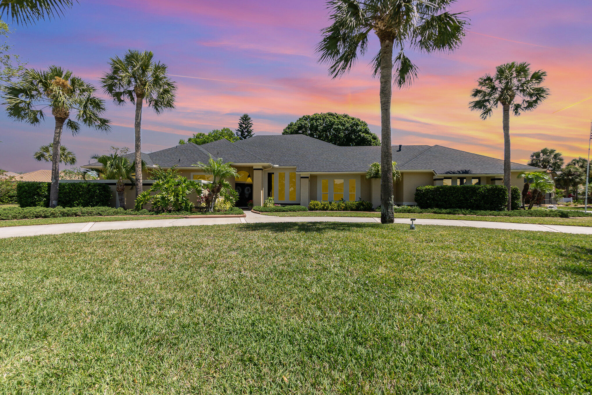 789 Oak Park Drive Melbourne, FL 32940 - Photo 36 of 44 a view of a house with a yard and palm trees