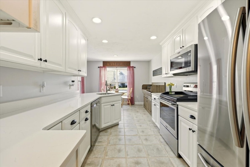 8 Country Circle, Unit 8 Norton, MA 02766 - Photo 17 of 42 a large kitchen with stainless steel appliances granite countertop a refrigerator a sink a stove and white cabinets