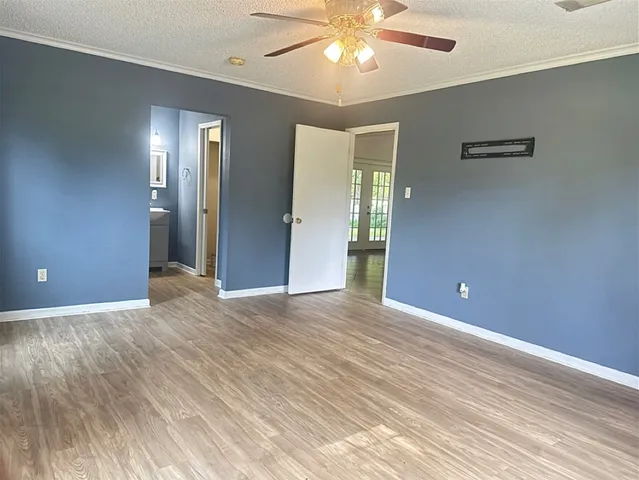 a view of an empty room with a chandelier fan