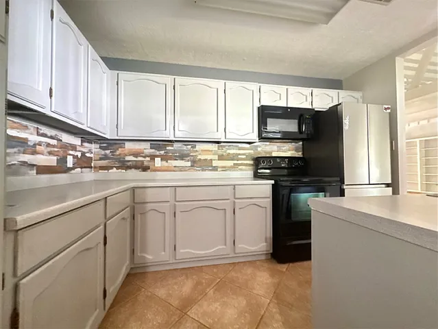 a kitchen with cabinets appliances a sink and a counter top space