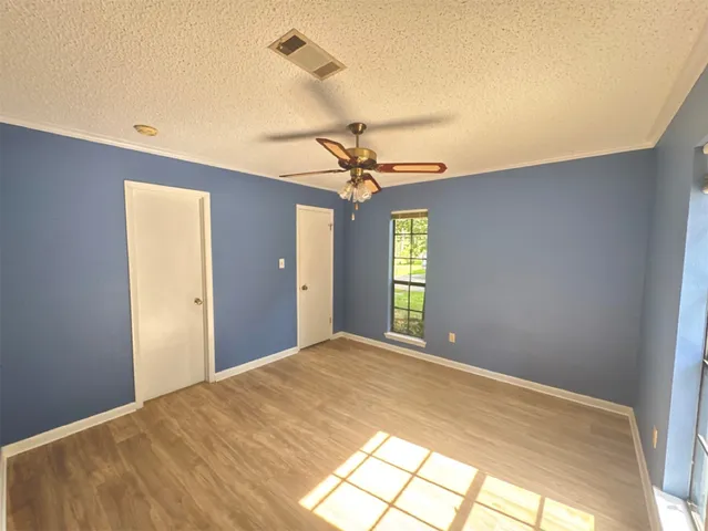 a view of a big room with windows and chandelier fan