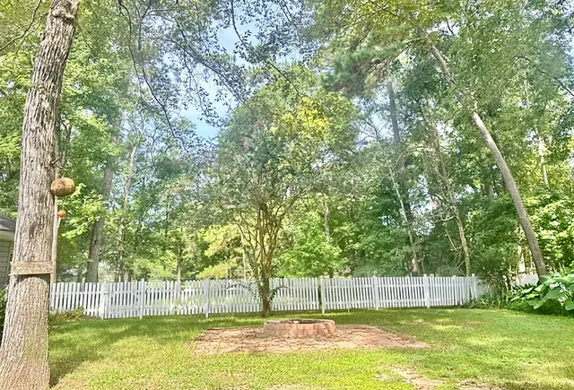 a view of a swimming pool with a big yard and large trees