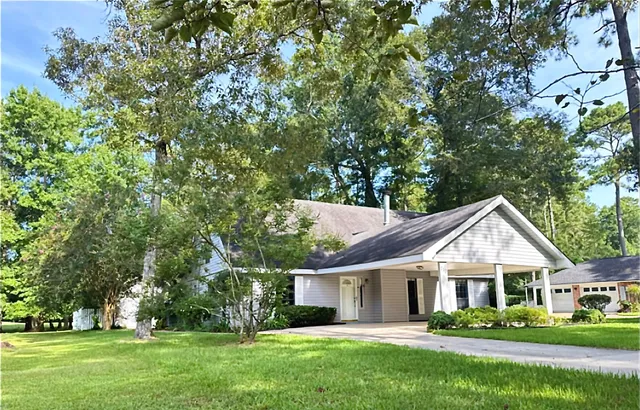 a front view of a house with a yard and green space
