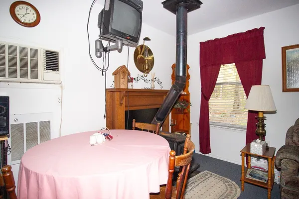a bed room with a bed and a lamp on dresser next to a window