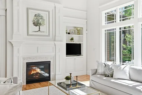 a living room with furniture a fireplace and a flat screen tv