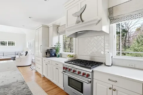 a kitchen with a stove and white cabinets