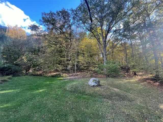 a view of a field with trees in front of main door