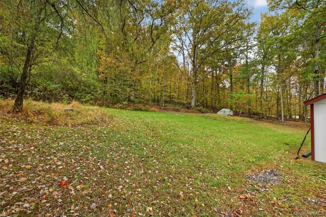 a view of a white house with a big yard and large trees